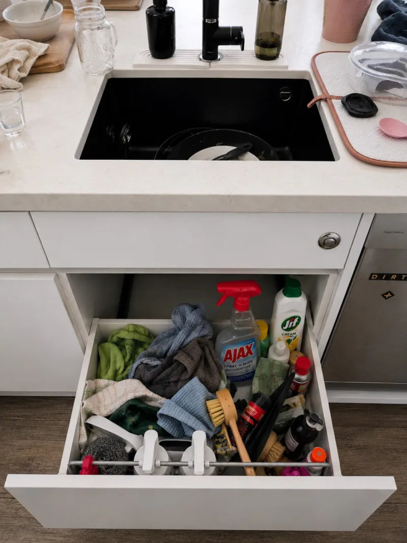 A crowded cleaning drawer before Crown Standard