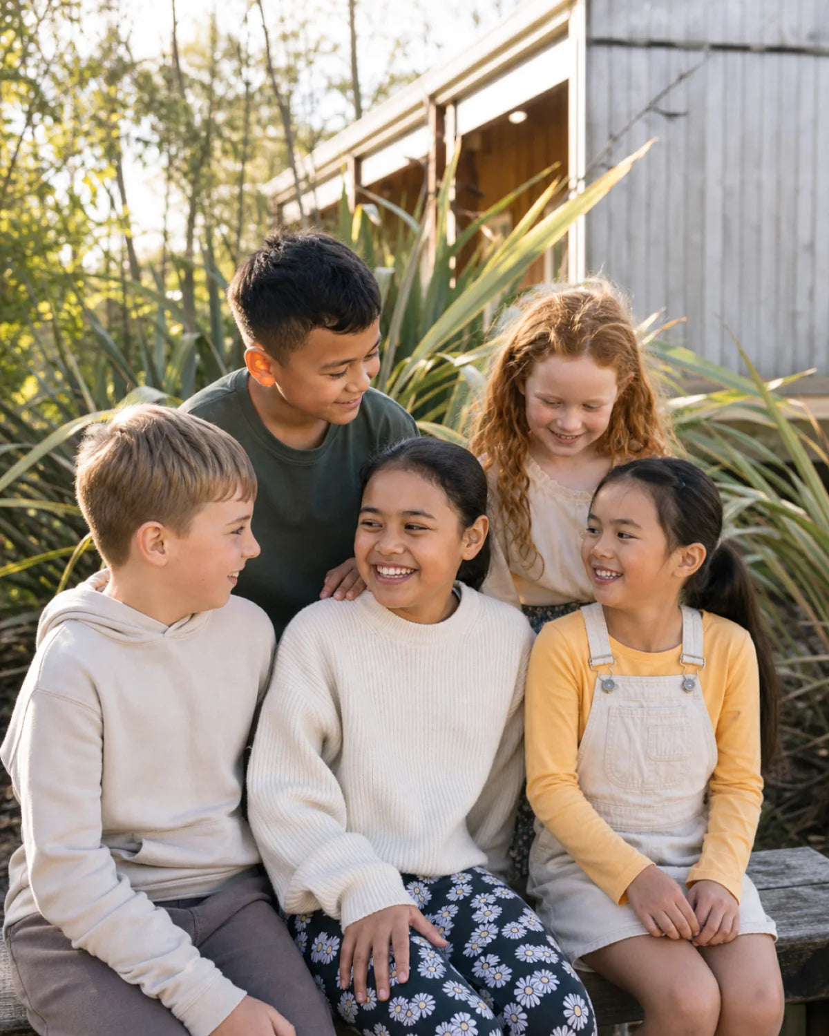 A diverse group of smiling New Zealand schoolchildren together outdoors